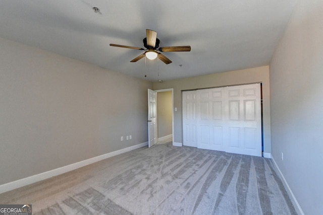 unfurnished bedroom featuring light carpet, ceiling fan, and a closet