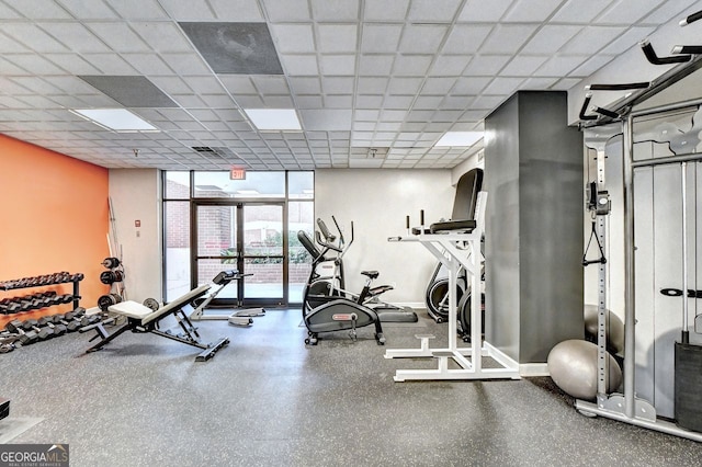 workout area with a paneled ceiling and expansive windows