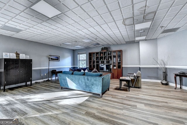 living room featuring hardwood / wood-style floors and a paneled ceiling