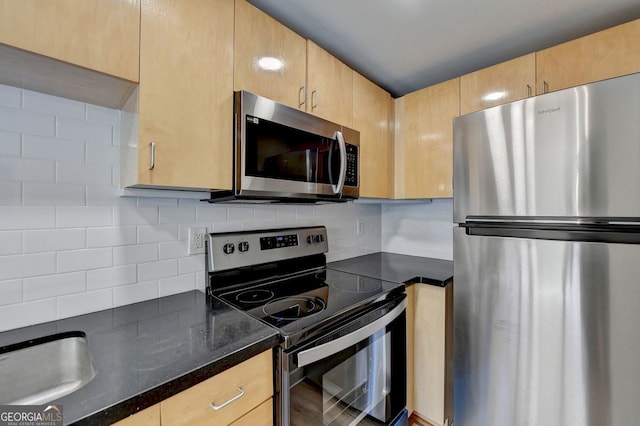 kitchen featuring light brown cabinetry, stainless steel appliances, and decorative backsplash