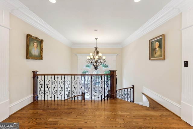 hallway with hardwood / wood-style floors, a notable chandelier, and ornamental molding