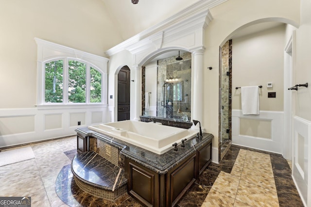 bathroom with sink, lofted ceiling, walk in shower, and decorative columns