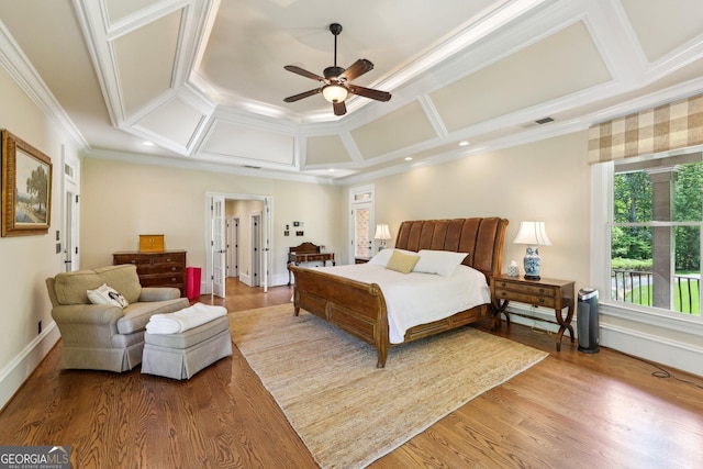 bedroom with ceiling fan, wood-type flooring, ornamental molding, and coffered ceiling