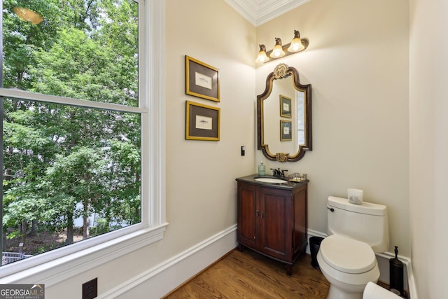 bathroom with crown molding, toilet, vanity, and hardwood / wood-style flooring