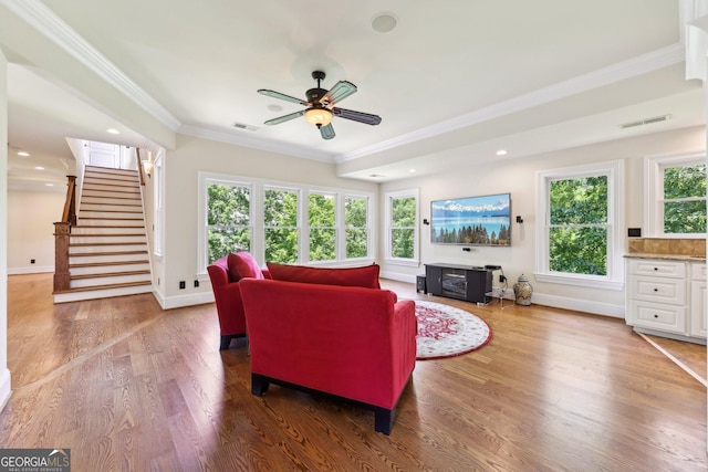 living room featuring hardwood / wood-style flooring, ceiling fan, plenty of natural light, and ornamental molding