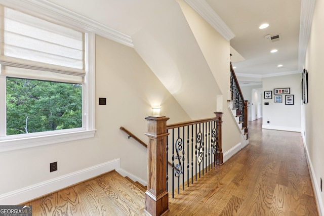 staircase featuring hardwood / wood-style floors and crown molding