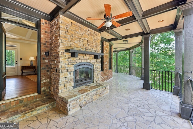 view of patio with an outdoor stone fireplace and ceiling fan