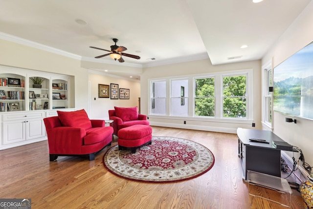 living room featuring ceiling fan, crown molding, and wood-type flooring