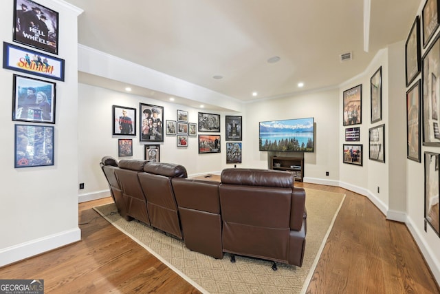 home theater room with hardwood / wood-style flooring and crown molding