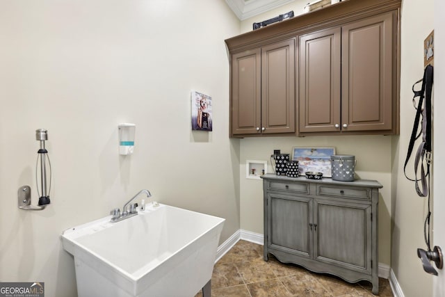 laundry area featuring hookup for a washing machine, crown molding, sink, and cabinets