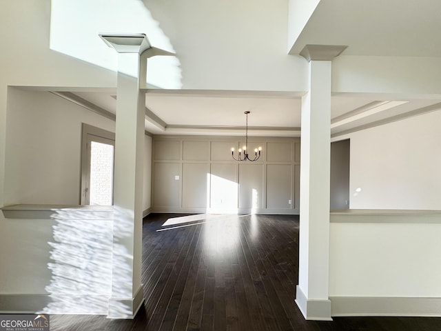 interior space featuring a tray ceiling, dark hardwood / wood-style flooring, and a notable chandelier