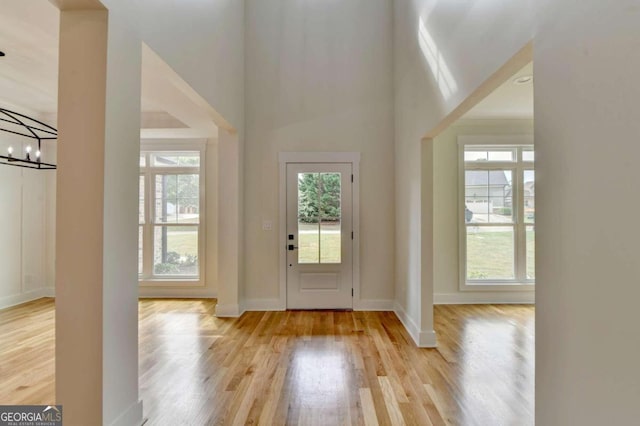 entryway featuring a wealth of natural light, light hardwood / wood-style flooring, and a chandelier