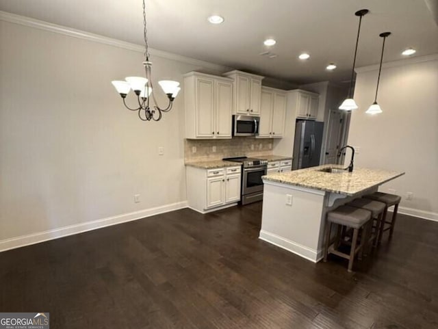 kitchen with appliances with stainless steel finishes, white cabinets, light stone counters, and dark hardwood / wood-style flooring