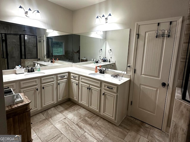 bathroom featuring a shower with door and vanity