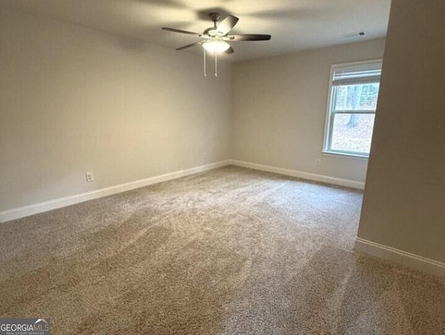 carpeted spare room featuring ceiling fan