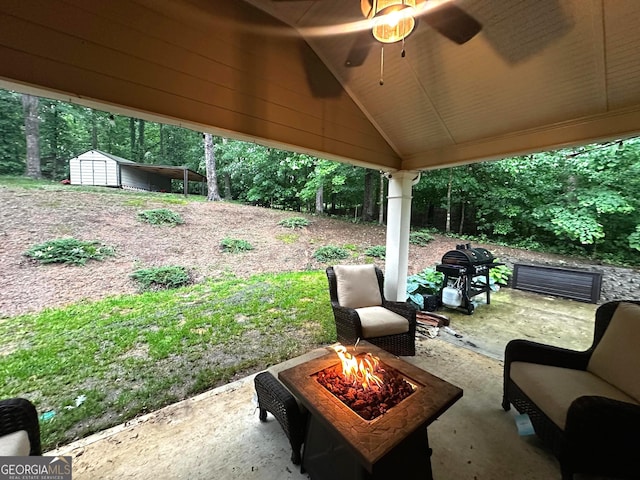 view of patio with a storage unit, grilling area, and a fire pit