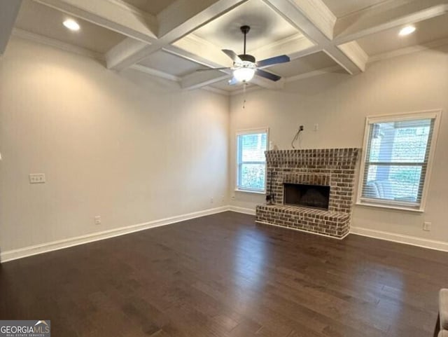 unfurnished living room with a wealth of natural light, ceiling fan, a brick fireplace, and dark hardwood / wood-style flooring