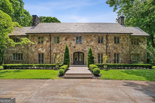 view of front facade with a front lawn and french doors