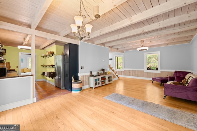 living room featuring beam ceiling, wood ceiling, and light wood-type flooring