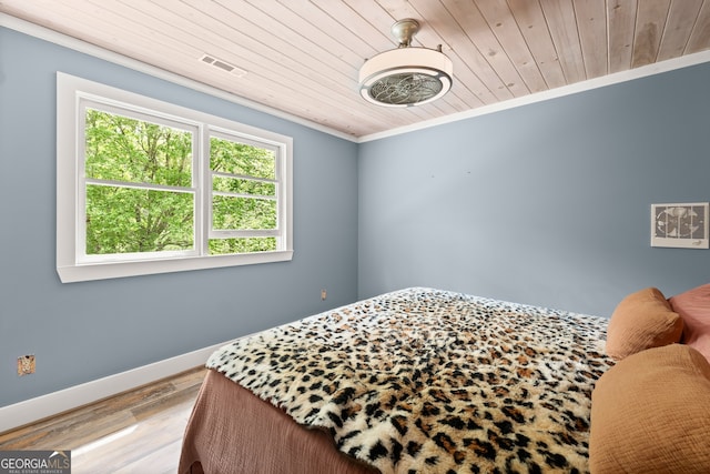 bedroom featuring wood-type flooring, ornamental molding, and wood ceiling