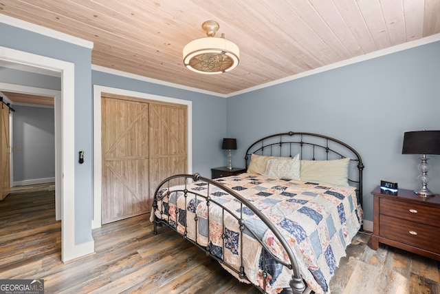 bedroom featuring crown molding, a barn door, hardwood / wood-style floors, and wooden ceiling