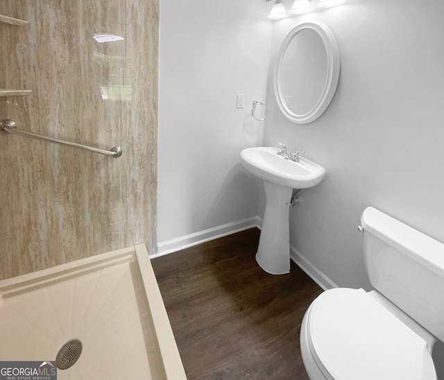 bathroom featuring hardwood / wood-style flooring, a shower, and toilet