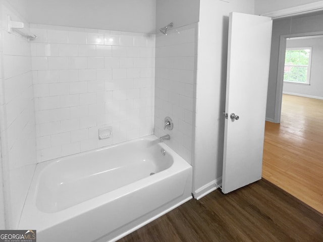 bathroom with hardwood / wood-style flooring and tiled shower / bath combo