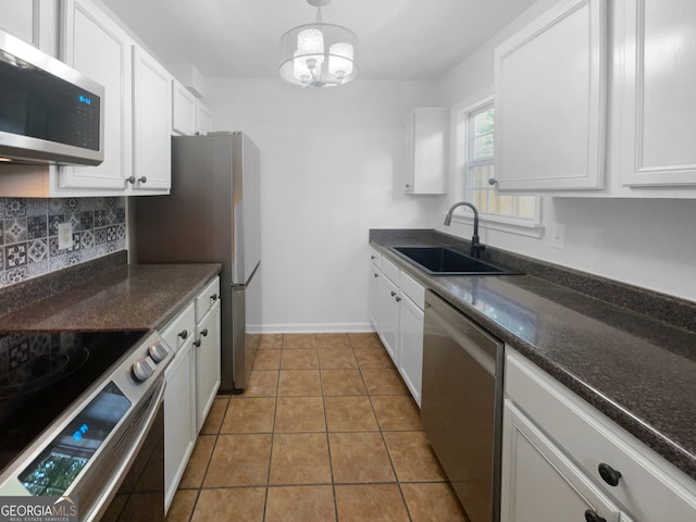 kitchen featuring tasteful backsplash, white cabinetry, appliances with stainless steel finishes, sink, and light tile floors