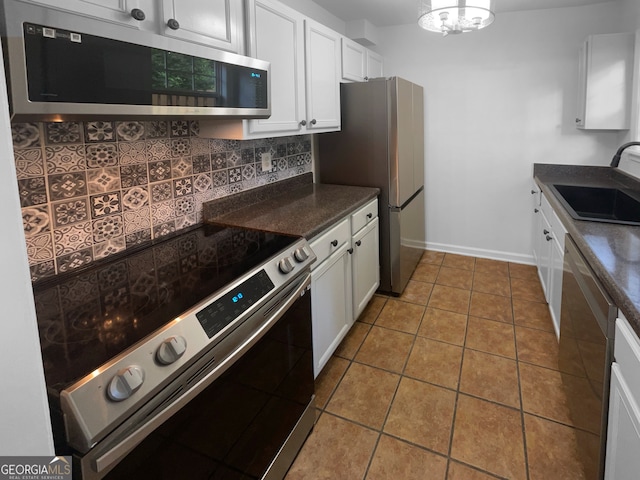 kitchen with white cabinetry, tile flooring, appliances with stainless steel finishes, sink, and tasteful backsplash