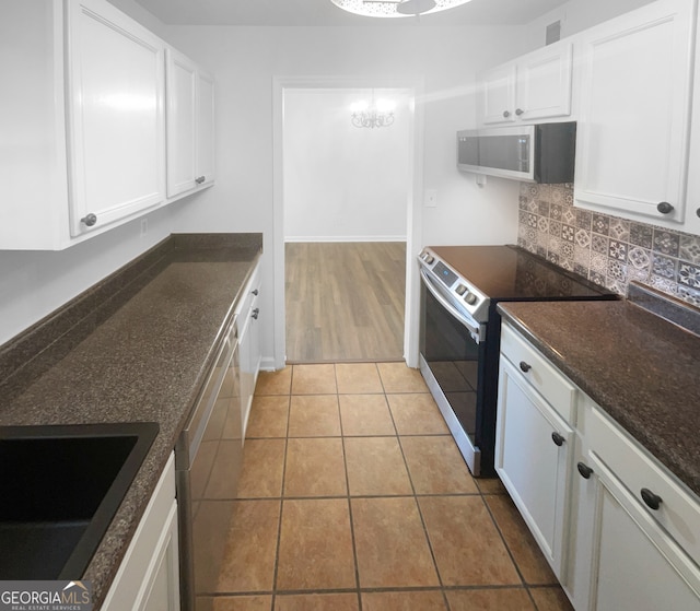 kitchen featuring backsplash, white cabinets, sink, electric stove, and light tile floors