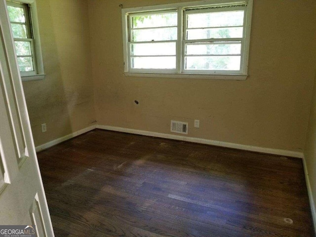 unfurnished room with plenty of natural light and dark hardwood / wood-style floors