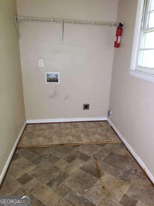 clothes washing area featuring washer hookup, dark tile flooring, and hookup for an electric dryer