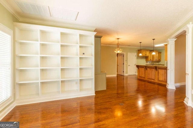 unfurnished living room featuring crown molding, a textured ceiling, decorative columns, and wood-type flooring