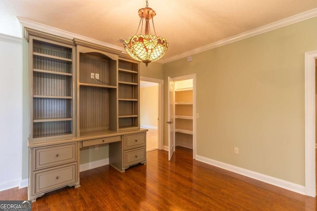 unfurnished office featuring built in desk, ornamental molding, and dark hardwood / wood-style floors