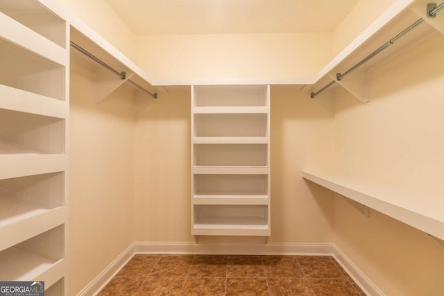 walk in closet featuring dark tile flooring