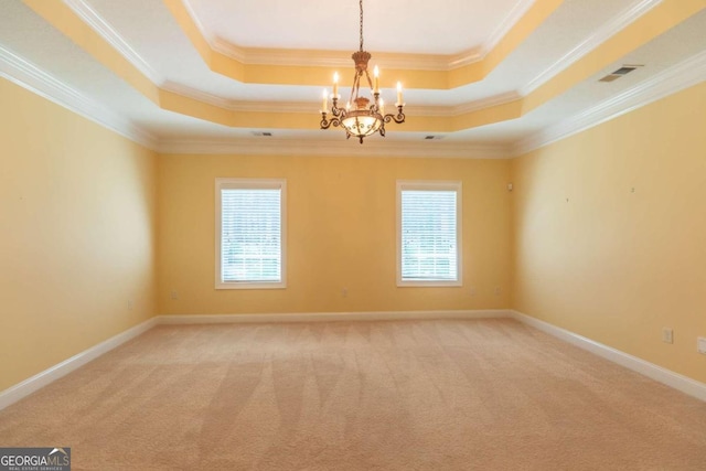 carpeted spare room with a healthy amount of sunlight, a chandelier, a raised ceiling, and ornamental molding