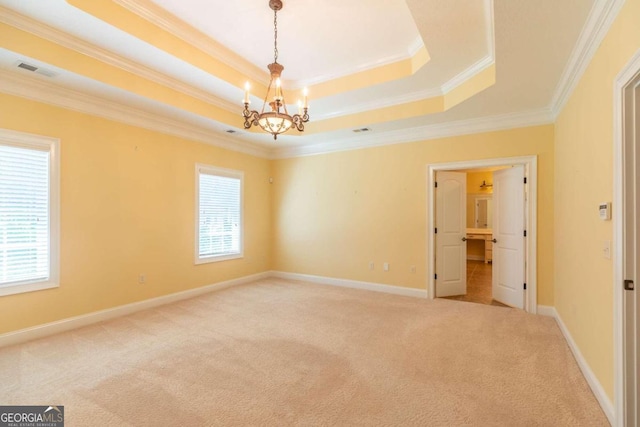 spare room featuring crown molding, carpet flooring, an inviting chandelier, and a raised ceiling