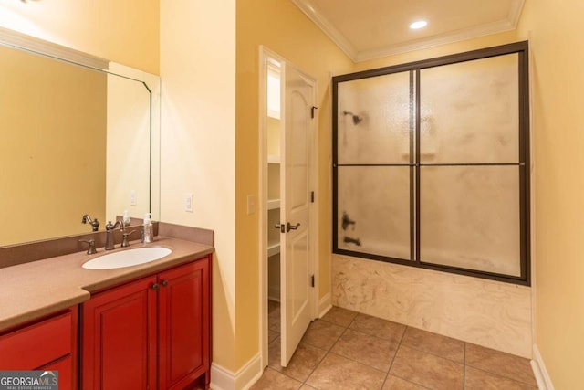 bathroom featuring tile floors, bath / shower combo with glass door, ornamental molding, and vanity with extensive cabinet space