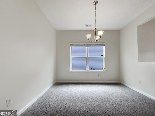 empty room featuring a notable chandelier and carpet floors