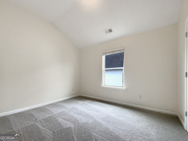 unfurnished room with vaulted ceiling and carpet flooring