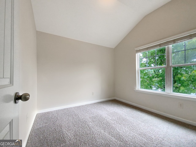 spare room featuring lofted ceiling and carpet