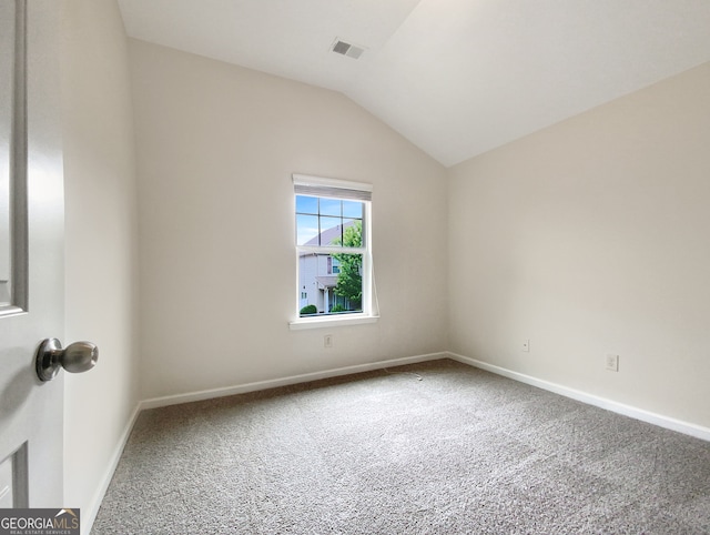 empty room featuring carpet and vaulted ceiling