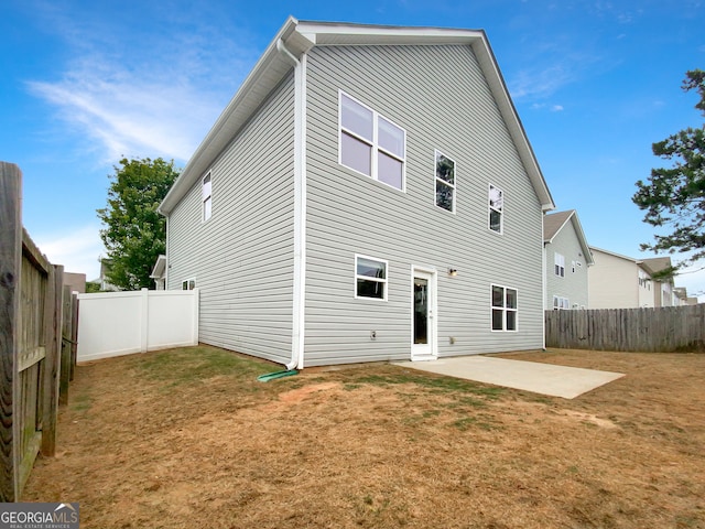 rear view of property featuring a patio area and a lawn