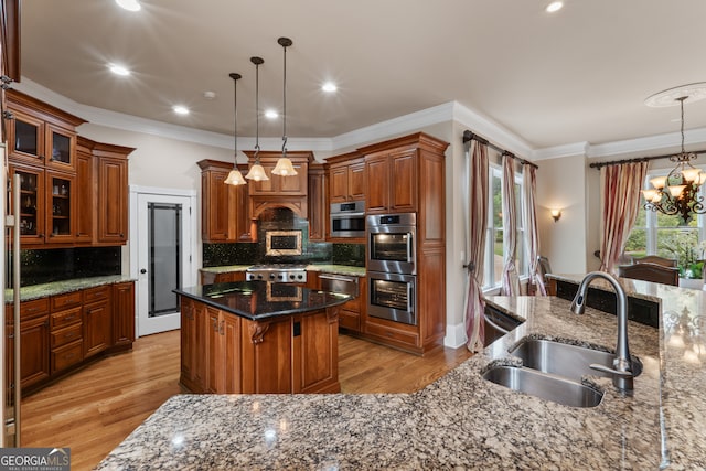 kitchen with double oven, dark stone counters, a kitchen island, backsplash, and sink