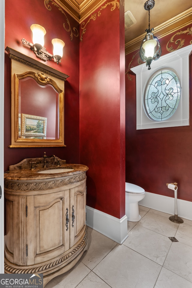 bathroom featuring tile flooring, vanity, toilet, and crown molding