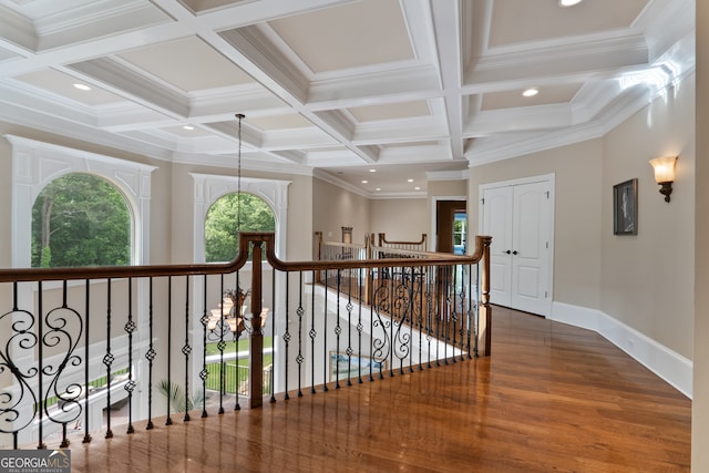 hallway with an inviting chandelier, dark hardwood / wood-style flooring, coffered ceiling, crown molding, and beamed ceiling