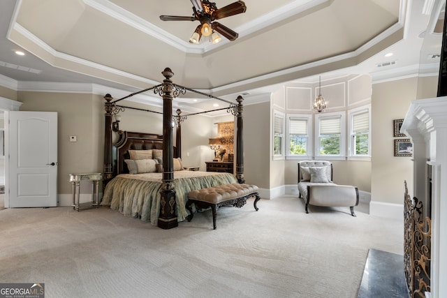 carpeted bedroom featuring ceiling fan with notable chandelier, a tray ceiling, and crown molding