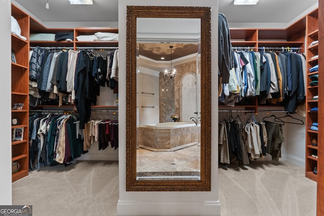 spacious closet featuring a notable chandelier and carpet floors