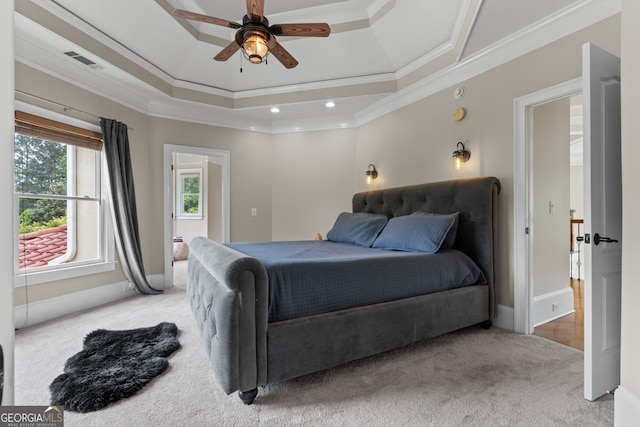 bedroom featuring a tray ceiling, ornamental molding, ceiling fan, and light colored carpet