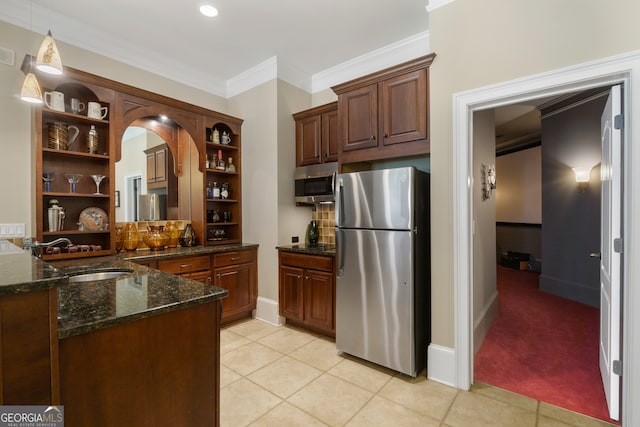 kitchen featuring dark stone counters, crown molding, stainless steel appliances, light tile flooring, and sink